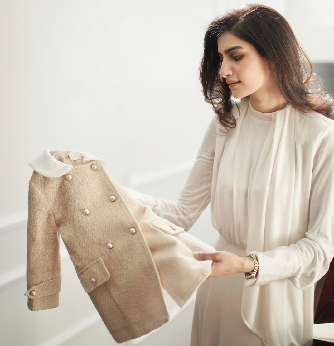 Sameen, founder of Petite Loom, holding a handcrafted children's jacket