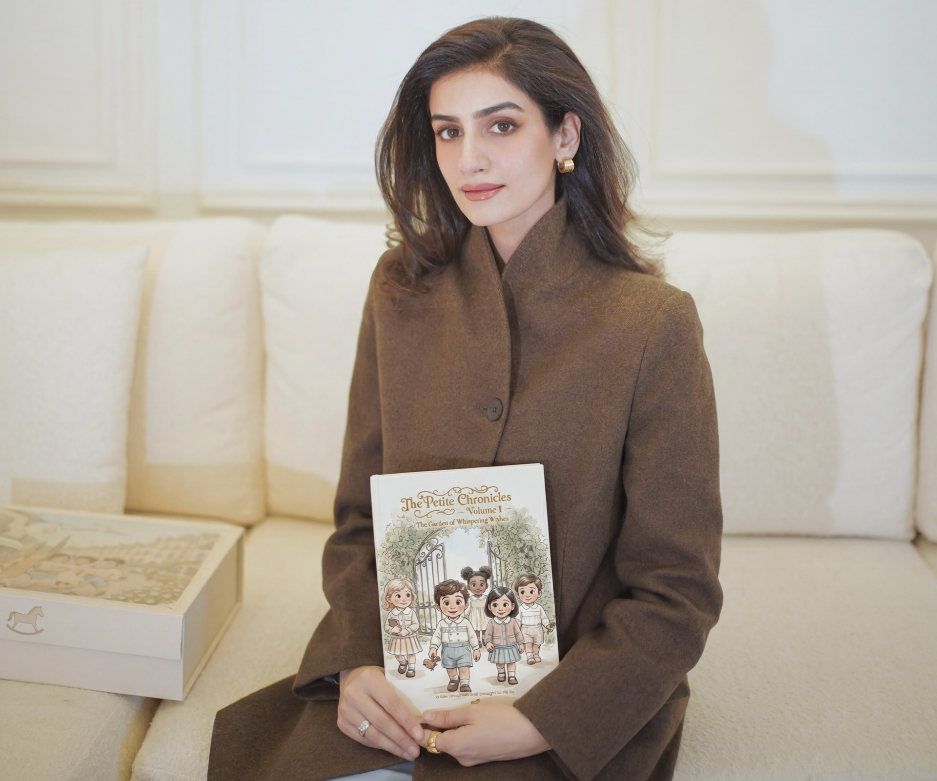 Sameen holding The Petite Chronicles storybook